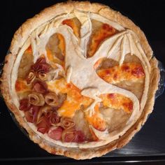 a close up of a pie with toppings in it on a black counter top