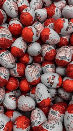 many red and white chocolate eggs are stacked on top of each other