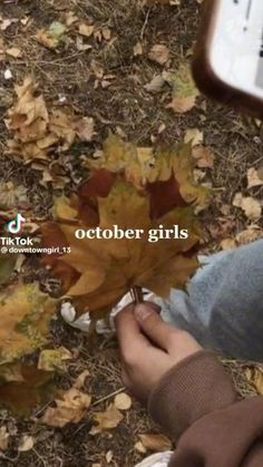 a person is holding an autumn leaf in their hand with the words october girls on it