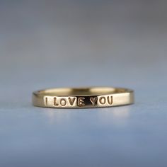 Show her how you feel with this sweet little gold ring.  "I LOVE YOU" is inscribed on this outside of the solid 14k gold ring. It has a smooth finish for a lovely shine.  This ring is ready to ship in a size 5.  If you need a different size, I am happy to make a ring exactly to your specifications. You can find the made to order version of this ring here https://www.etsy.com/listing/99515676.  High quality 1 mm stamps were used to stamp the tiny but readable words on the ring. To see how small the letters are, take a look at a penny. The words "In God we Trust" are the same size. -------------------- About the ring - Handmade from 14k yellow gold. - 2 mm wide (5/64 of an inch) wide - Smooth shiny finish - Inscription outside: I LOVE YOU -------------------- The ring will arrive gift wrappe I Love You Ring, Paper Ring, A Penny, In God We Trust, 14k Gold Ring, Ring Handmade, Ring Box, Handmade Ring, Gold Ring