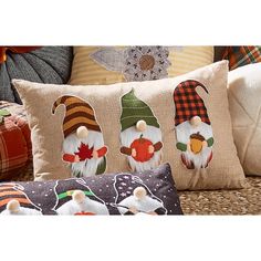 three decorative gnome pillows on a wicker couch