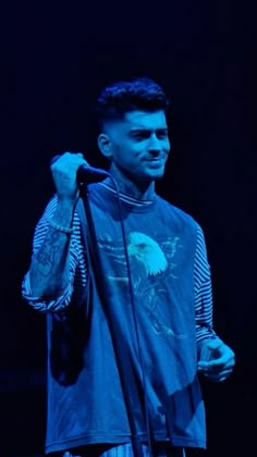 a young man holding a microphone on stage