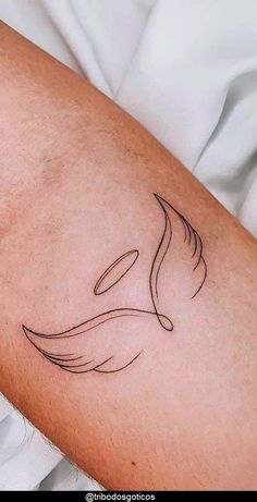 a close up of a person's arm with a bird tattoo on the arm