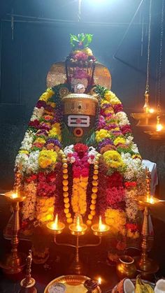 an idol is adorned with flowers and candles