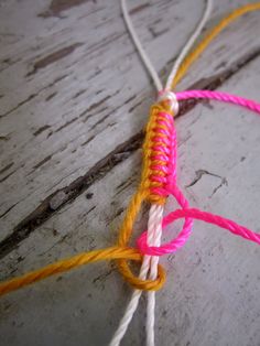 an orange and pink piece of string on wood