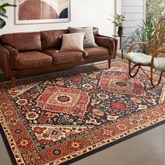 a living room filled with furniture and rugs on top of a hard wood floor