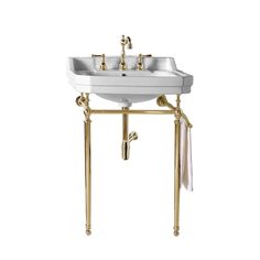 a white sink sitting under a mirror next to a golden stand with two faucets