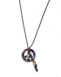 "A Boho peace sign necklace featuring a pendant in speckled turquoise blue and burgundy, with painted white flowers and tiny Swarovski crystal rhinestone accents! Dangling alongside the artful pendant, rows of genuine turquoise nuggets and colorful glass beads add flirty movement! And you have your choice of chain length so it will be the perfect length! Add this super-cute piece of Boho-style wearable art to your collection! Ceramic Pendant 1 1/4\" round, Antiqued Gold-plated Necklace w/ Lobste Bohemian Peace Sign Necklace For Gift, Bohemian Charm Necklaces With Round Beads, Boho Peace Sign, Blue And Burgundy, Peace Necklace, Peace Sign Necklace, Sign Necklace, Ceramic Pendant, Genuine Turquoise