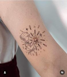 a woman's arm with a tattoo on it that has fireworks coming out of it