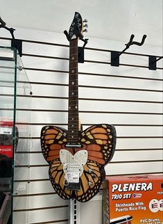 a butterfly shaped guitar hanging from the side of a wall