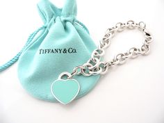 Overview:Here is a gift that she will surely adore! It is shiny, stylish, and super versatile! This piece will make someone REALLY happy! :) Offered for sale is a wonderful Return to Tiffany & Co. Sterling Silver and Blue Enamel Heart Charm Bracelet. Hanging from its bright Tiffany silver chain is a very classic and very pretty Return to Tiffany Heart charm - with Blue Enamel on the other side! The Blue Enamel Heart Charm hangs from a Tiffany & Co. Silver clasp (opens / closes) and thus allows y Designer Blue Bracelet Jewelry, Designer Bracelets With Polished Finish For Gift, Designer Polished Finish Bracelets For Gift, Elegant Blue Bracelets For Valentine's Day, Elegant Heart-shaped Bracelet For Gift, Elegant Valentine's Day Jewelry, Luxury Heart Charm Bracelet Gift, Elegant Turquoise Bracelets, Luxury Blue Jewelry For Valentine's Day