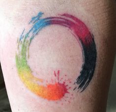 a person with a colorful tattoo on their leg that has paint splatters all over it