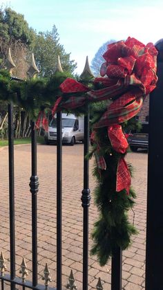 a christmas wreath on top of a gate