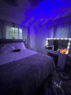 a bed sitting under a purple light in a bedroom