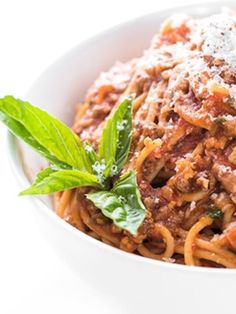 a white bowl filled with pasta covered in sauce and topped with parmesan cheese