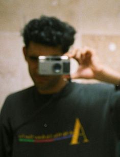 a man taking a selfie in front of a mirror with his cell phone up to his face