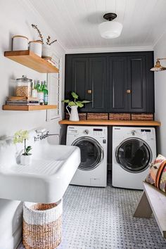 a washer and dryer in a small room with open shelving on the wall