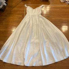 a white dress sitting on top of a wooden floor