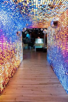 the inside of a building with wooden floors and colorful lights