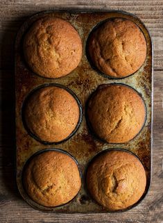 six muffins in a baking pan on a wooden table