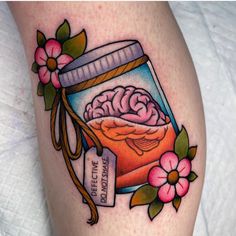 a tattoo with a jar filled with food and flowers on the side of her leg