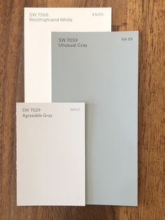 three different shades of white paint sitting on top of a wooden table