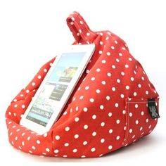 a red and white polka dot bag with an electronic device in it's pocket