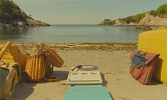 an old record player sitting on the beach next to a basket and picnic table with food