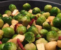 brussel sprouts and apples are being cooked in a pan on the stove