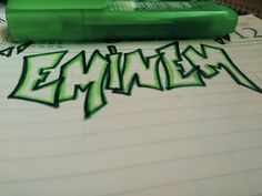 a green marker pen sitting on top of a piece of paper with graffiti written on it