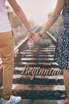 two people holding hands while standing on train tracks with the words, the new beginning