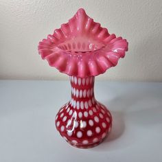 a pink vase with white dots on it