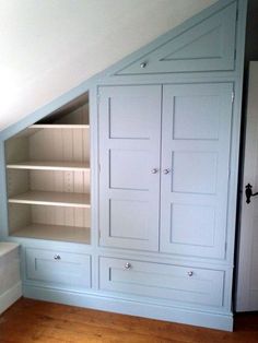 an attic bedroom with built in bookshelves and cabinets