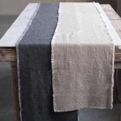 a table with two different colored linens on it and a wooden bench in the background