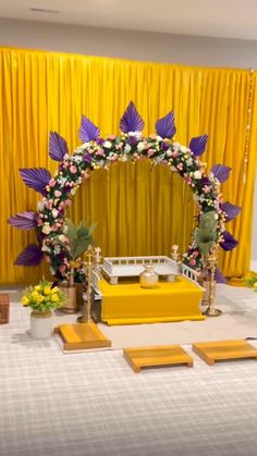 the altar is decorated with flowers and gold stands in front of yellow drapes