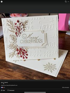 a white christmas card sitting on top of a wooden table