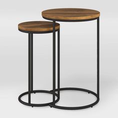 two tables with metal legs and wood top, one is black and the other is brown