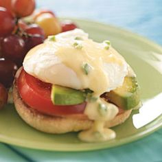 an open face sandwich with tomatoes, cucumber, and cheese on a green plate