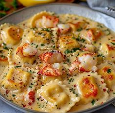 a plate of pasta with shrimp and cheese on it, garnished with parsley