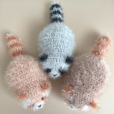 two small stuffed animals sitting next to each other on a white surface with no one around them