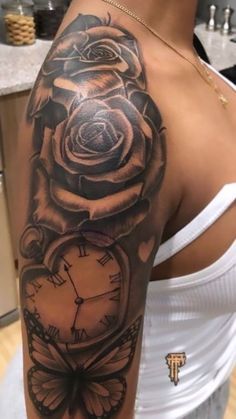 a woman with a rose and clock tattoo on her arm