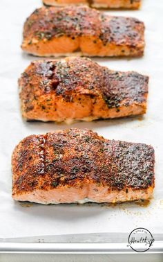 four salmon fillets on a baking sheet ready to be cooked in the oven for dinner