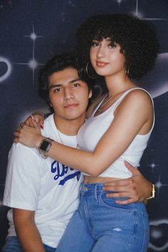 a young man and woman are posing for a photo in front of a star background