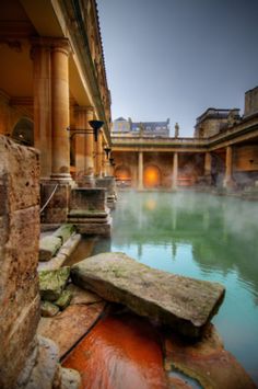 a large body of water surrounded by stone pillars and buildings with columns on each side