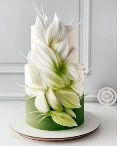 a green and white cake with flowers on top