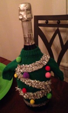 a wine bottle decorated like a christmas tree with silver sequins on the top