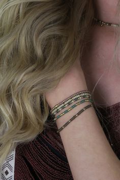 a woman with blonde hair wearing three bracelets