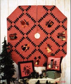 a red wall hanging on the side of a white building with christmas decorations and trees