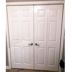 two white closet doors in a room with tile flooring