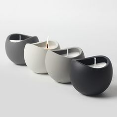 three white and black candles sitting next to each other